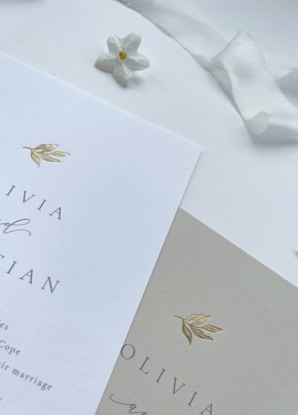 Luxury gold foil elegant leaf wedding invitation on white or nude card. Features an illustration of an elegant leaf stamped in hot foil.