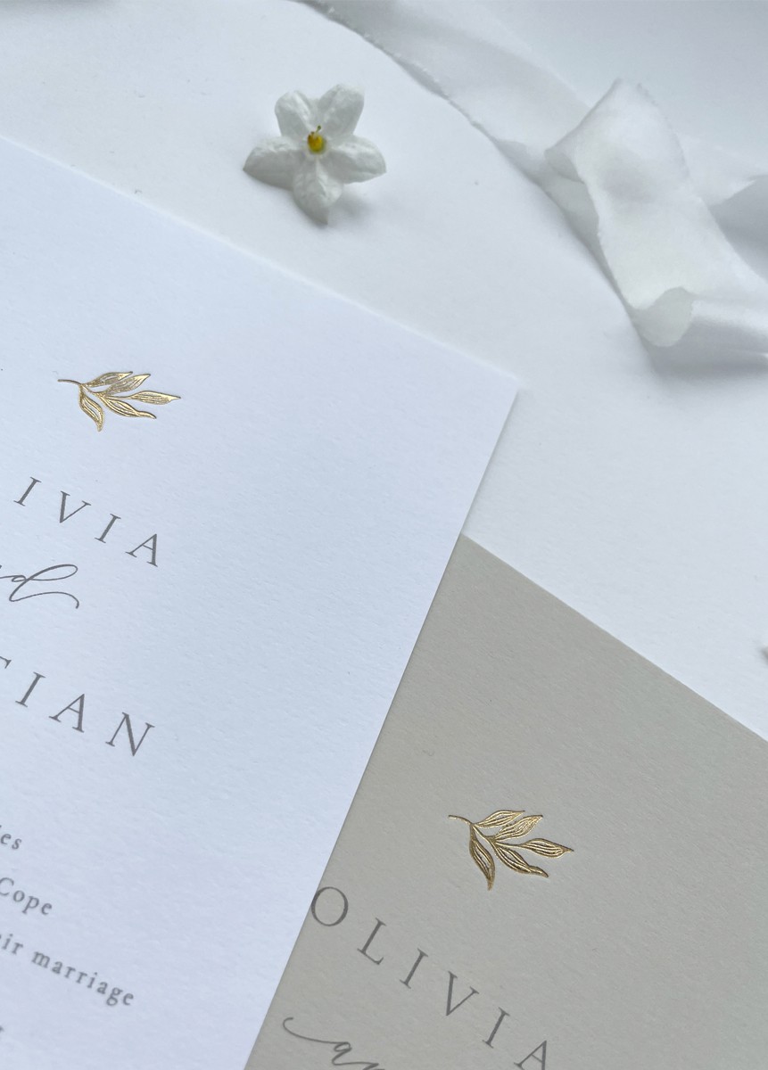 Luxury gold foil elegant leaf wedding invitation on white or nude card. Features an illustration of an elegant leaf stamped in hot foil.
