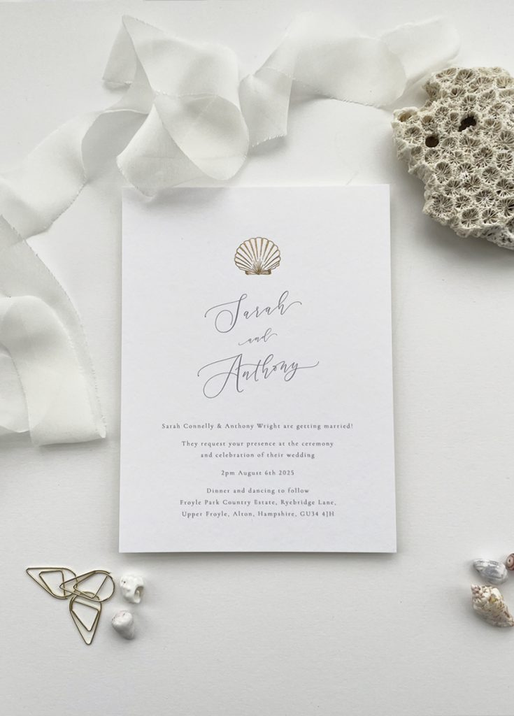 modern minimalist sea shell wedding Invite card with a gold foil shell hand pressed in luxurious foil on the front, personalised and printed on white card with a simple calligraphy font