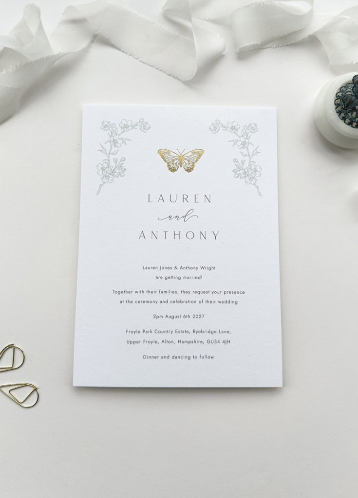 Luxury wedding invitation with minimal gold foil butterfly and sage green floral accents, printed on premium white card with elegant calligraphy; ideal for romantic, garden, or boho weddings.