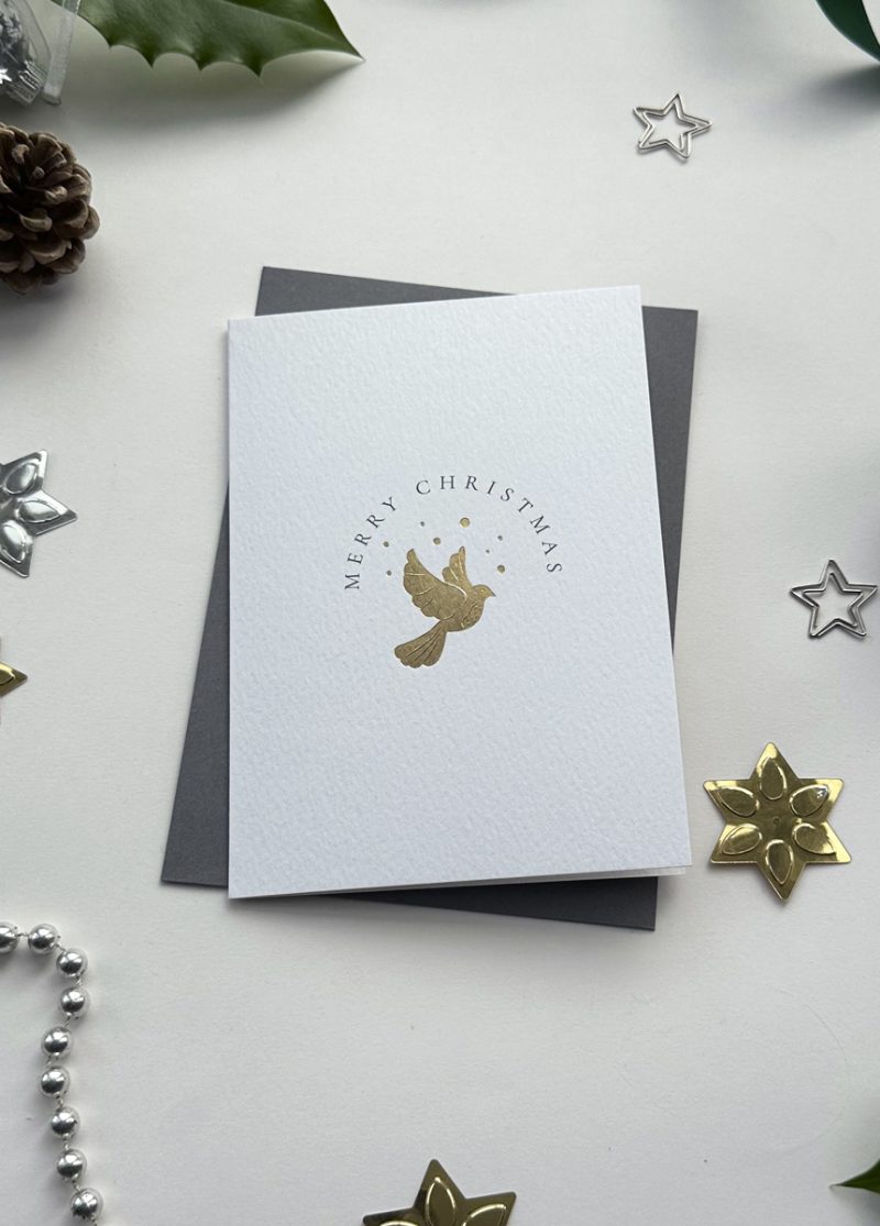 Elegant minimalist Christmas card featuring a gold foil dove of peace design, surrounded by festive star decorations.