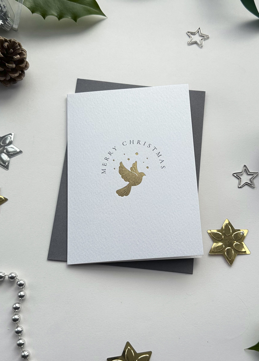 Elegant minimalist Christmas card featuring a gold foil dove of peace design, surrounded by festive star decorations.
