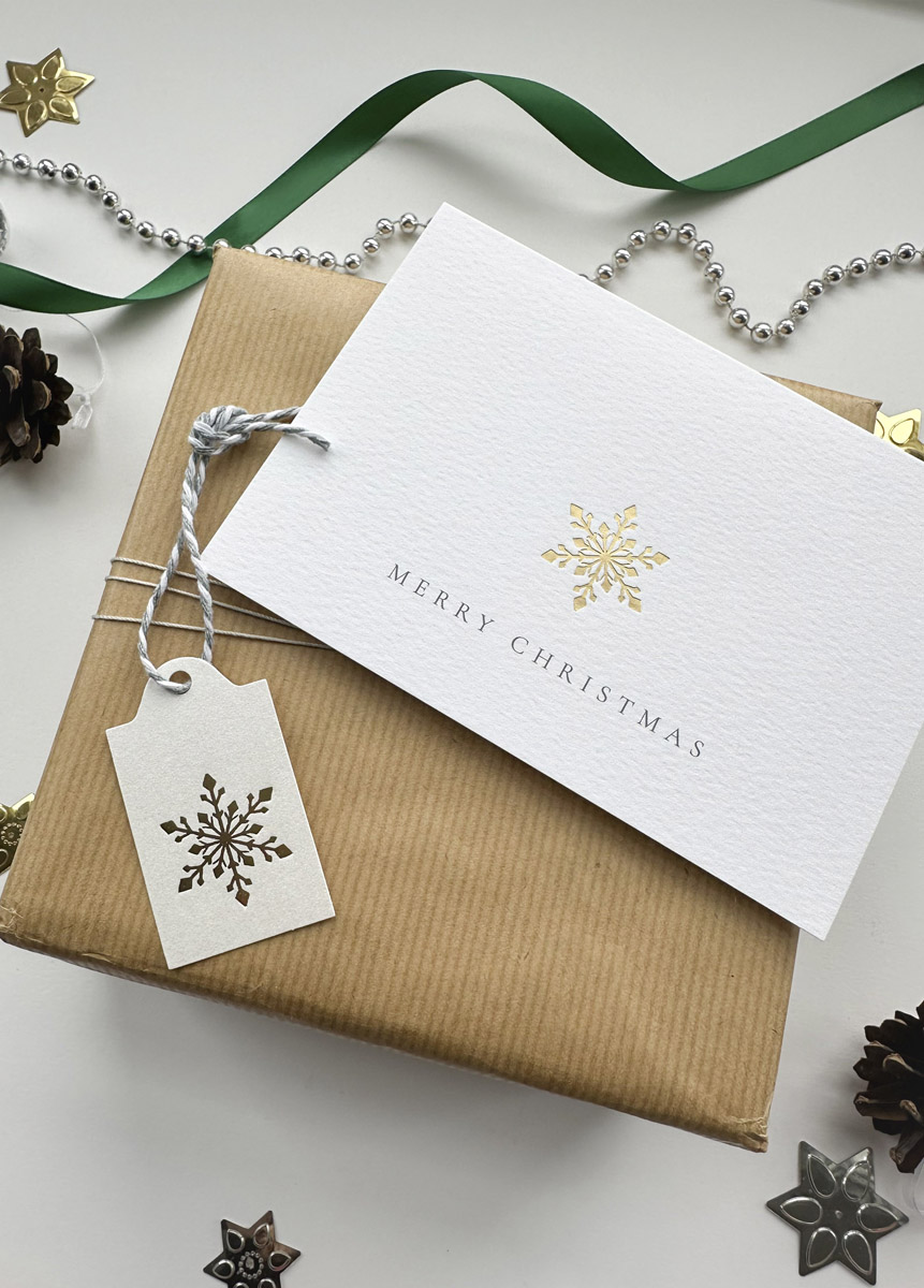 Luxury gold foil snowflake gift tag on kraft wrapped Christmas present