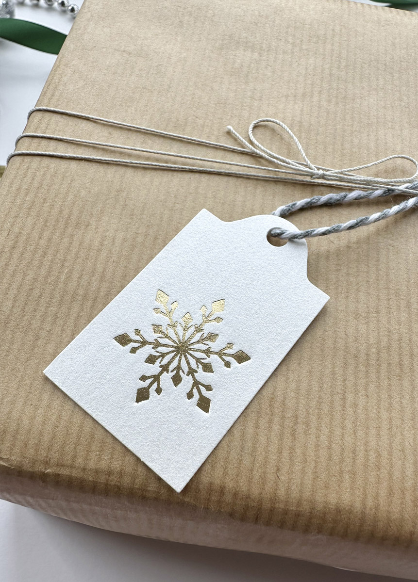 Luxury stationery tag with foil snowflake on pearlescent white card
