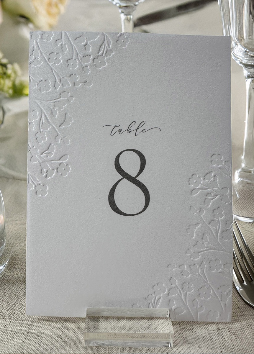 Floral debossed wedding table number designed to coordinate with luxury cotton card wedding stationery.