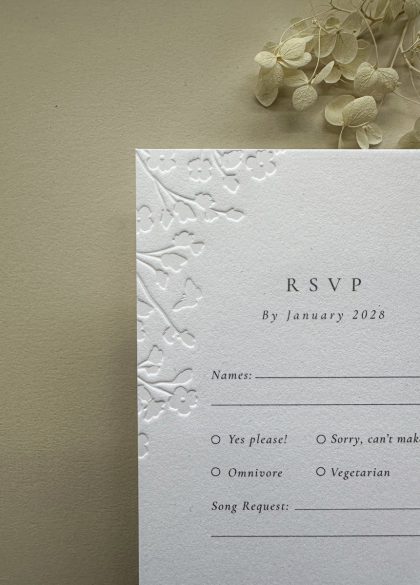 Floral embossed wedding RSVP card on premium cotton card, matching luxury wedding invitation suite.