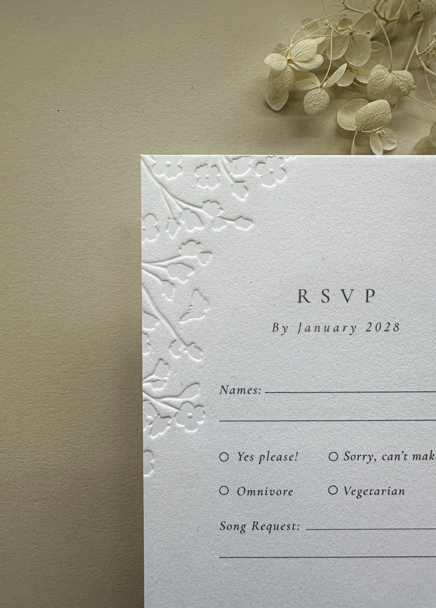 Floral embossed wedding RSVP card on premium cotton card, matching luxury wedding invitation suite.
