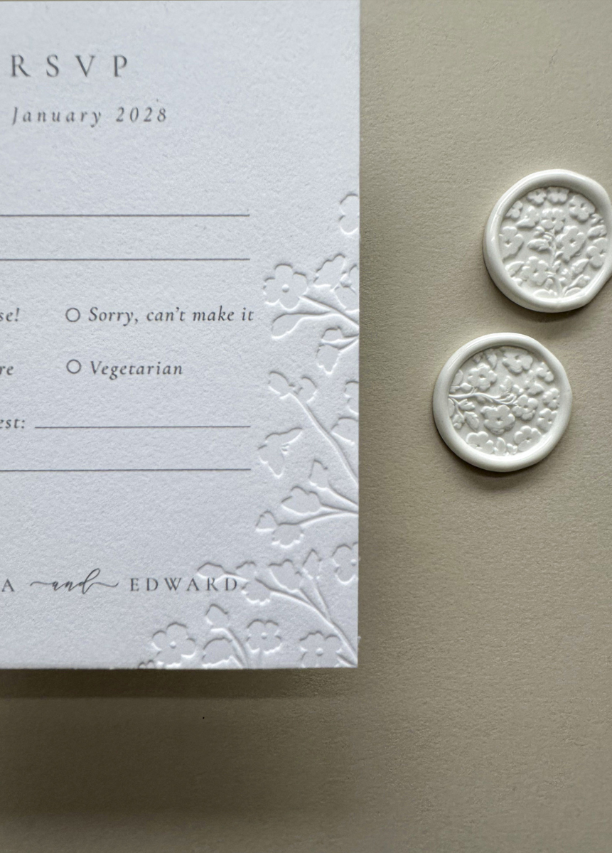 Luxury cotton card RSVP featuring delicate floral embossing and minimalist wedding stationery design.