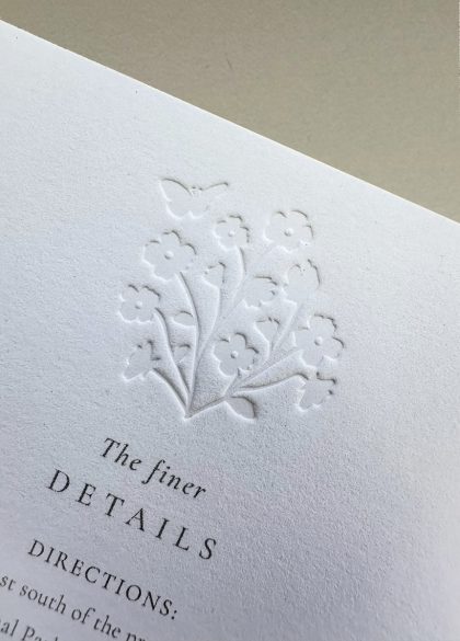Elegant wedding information card featuring delicate floral embossing and premium cotton paper in a timeless design.