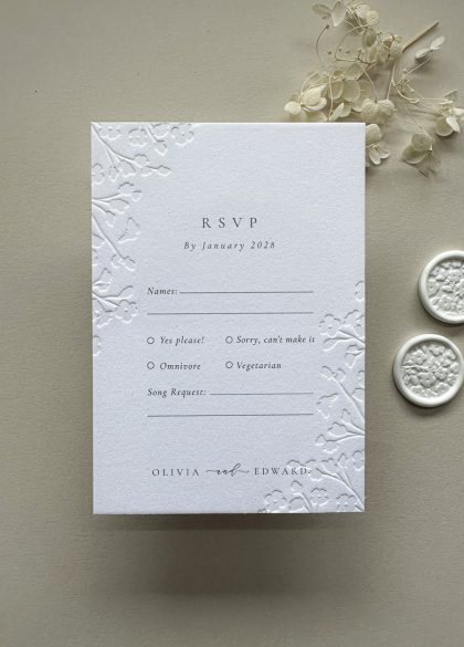 Luxury floral embossed RSVP card printed on thick cotton card with elegant typography and botanical embossed detailing.