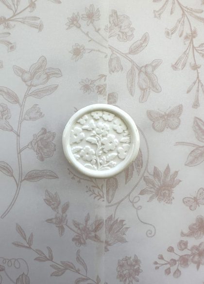 Botanical wedding wax seal used to secure a luxury vellum invitation wrap.