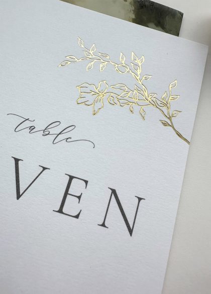 Close up of luxury vintage rose wedding table name card with gold foil details and minimalist type