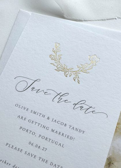 Luxury gold foil rose Save the Date card printed on premium white cotton card with an elegant floral design and timeless typography.