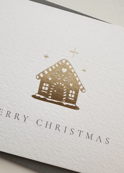 Close-up of the gold foil gingerbread house illustration on a luxury Christmas card.